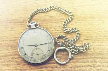 Old pocket watch on a wooden background