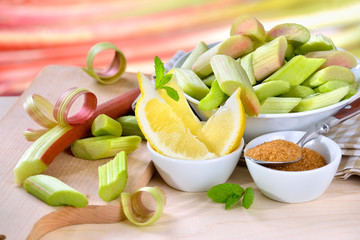 Roher Rhabarber geschält und geschnitten mit den weiteren Kompott-Zutaten Zitrone und brauner Zucker - Cut and peeled raw rhubarb with other compote ingredients brown sugar and lemon