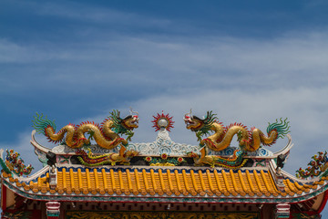 Fototapeta premium Chinese dragons on a temple roof with blue sky. 
