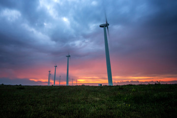 Obraz premium Wind turbines generating electricity against sunrise