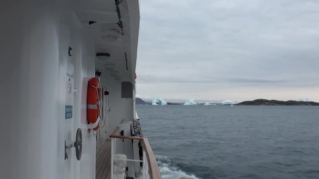 Icebreaker breaks the ice and move forward in Arctic. Fantastic wonderful amazing video grenland nature iceland. Lovely shooting the life of nature, seaside and mountains. Global warming.