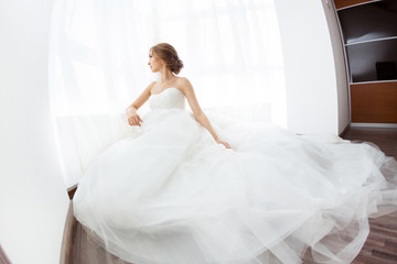 Fototapeta premium Brides beauty. Young woman in wedding dress indoors