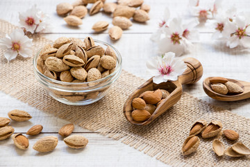 Almond nuts in bowl and almond flowers in the frame.