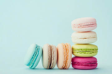 Cake macaron or macaroon on turquoise background, flavor almond cookies, pastel colors, vintage card