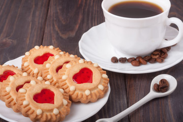 coffee cup with beans and cookies on the wooden table