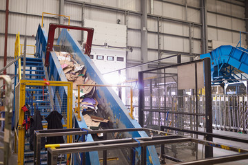 Fototapeta na wymiar Waste cardboard entering recycling plant on a conveyor belt