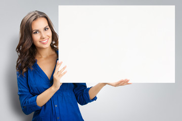 Young happy smiling woman showing blank signboard, on grey