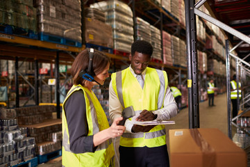 Warehouse manager talking with woman using barcode reader