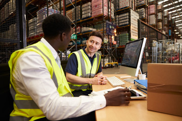 Staff discuss warehouse logistics in an on-site office