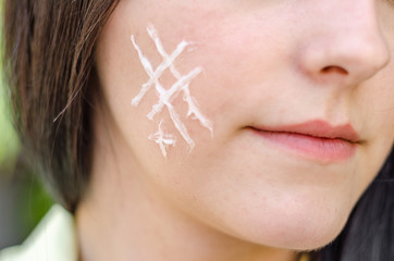 Girl draws on the skin cream