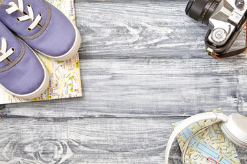 Vacation and travel items. Travel concept -  headphones, camera, shoes, map  on a wooden background