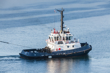 Tug boat with white superstructure underway