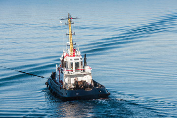 Tug boat with white superstructure underway