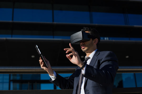 Businessman using tablet computer and virtual reality glasses