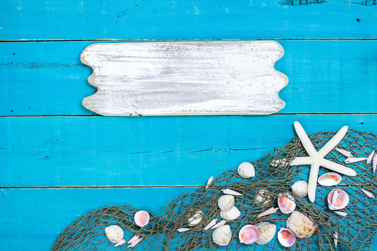 Blank rustic wood sign with seashells and fish net border