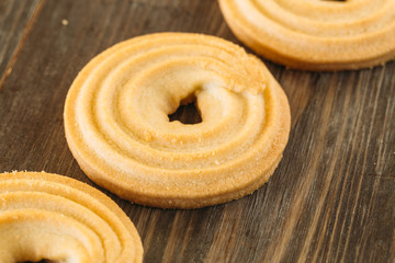 tasty butter biscuit rings on wooden background