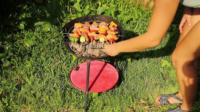 Barbecue at summer weekend. Woman preparing the grill.