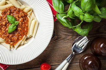 Penne a bolognese on white plate.