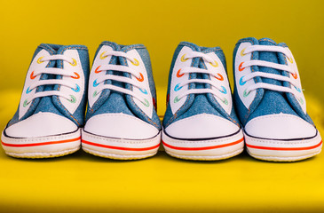 Baby sneakers on yellow background