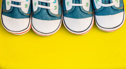 Baby sneakers on yellow background