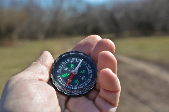 Compass in the hand on a walk.