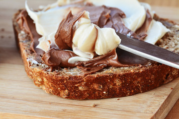 Chocolate and vanilla creamy spread on brown whole wheat bread slice