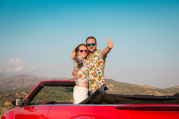 Happy couple travel by car in the mountains
