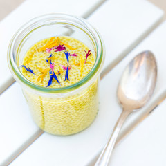 delicious yellow saffron chia pudding with edible dried flower