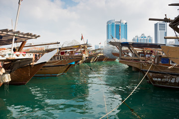 Fototapeta na wymiar Abu Dhabi buildings skyline with old fishing boats