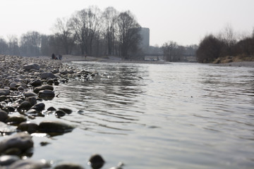 Steinwerfen am Flussufer der Isar