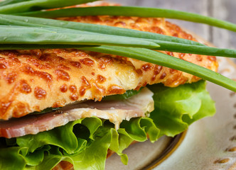 Tasty ham sandwich with salad leaf, cheese and green onion  in a cheese bread, homemade on breakfast.