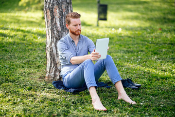 Obraz premium Handsome student reading in nature