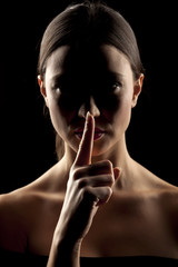 silhouette portrait of a woman with a finger in a position to silence