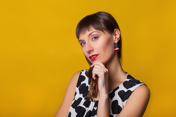 Closeup fashion portrait of beautiful model woman with bright makeup. Beauty face. Isolated on orange or yellow colorful background in studio.