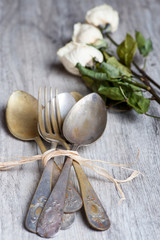 various spoons and forks entwined on rustic wooden table