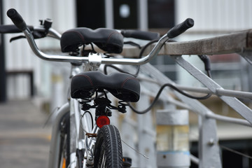 Fototapeta na wymiar Tandem bicycle chained to metal railing with chain lock.