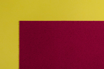 Fototapeta premium Eva foam ethylene vinyl acetate sponge plush red surface on lemon yellow smooth background