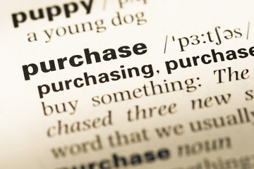 Obraz premium Close up of old English dictionary page with word purchase