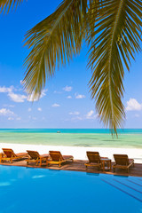Fototapeta na wymiar Loungers and pool on Maldives beach