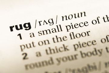 Obraz premium Close up of old English dictionary page with word rug