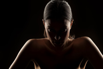 silhouette portrait of a woman with naked shoulders on a black background