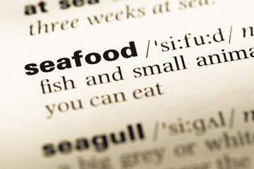Close up of old English dictionary page with word seafood