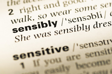 Fototapeta premium Close up of old English dictionary page with word sensibly