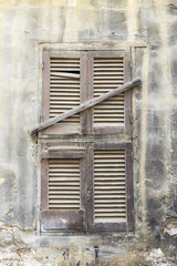 Old wooden window, sealed with wooden planks.