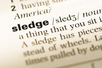 Obraz premium Close up of old English dictionary page with word sledge