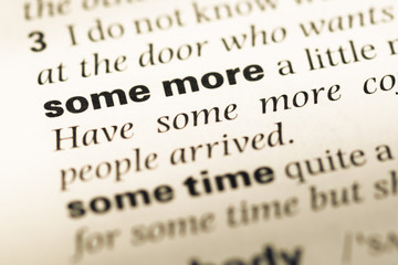 Obraz premium Close up of old English dictionary page with word some more