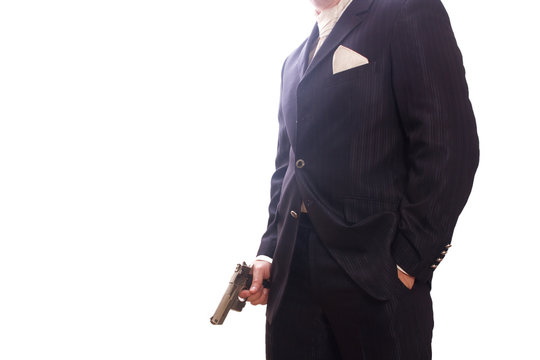 Geschäftsmann im Anzug mit Pistole in der Hand