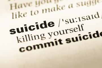 Fototapeta premium Close up of old English dictionary page with word suicide