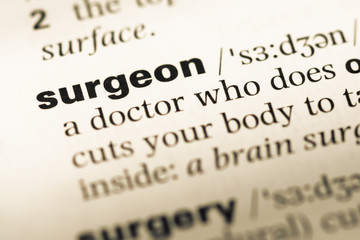 Obraz premium Close up of old English dictionary page with word surgeon