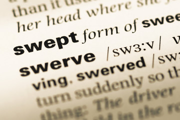 Fototapeta premium Close up of old English dictionary page with word swept